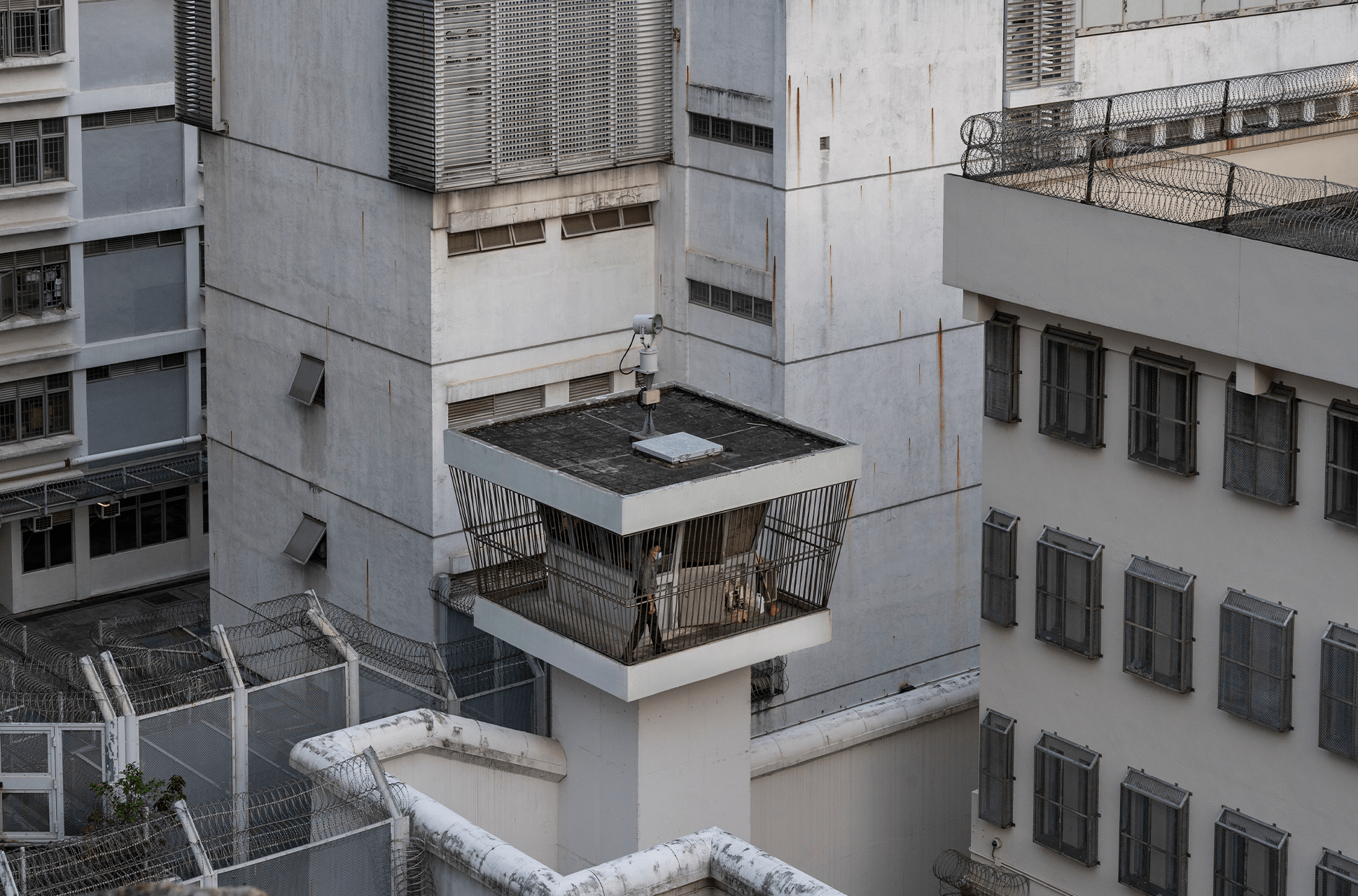 Un guardia de la prisión patrulla alrededor de la torre de vigilancia en el Centro de Recepción Lai Chi Kok, Hong Kong, China. Fotografía de Miguel Candela / REUTERS